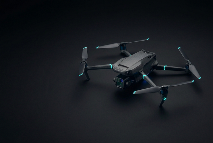 Gray quadcopter drones with blue LED accents arranged diagonally on a dark black background.