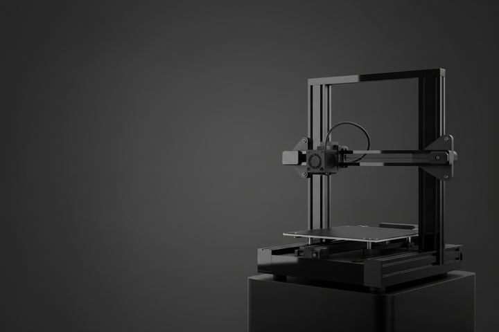 A black 3D printer with a rectangular frame shown on a dark background.